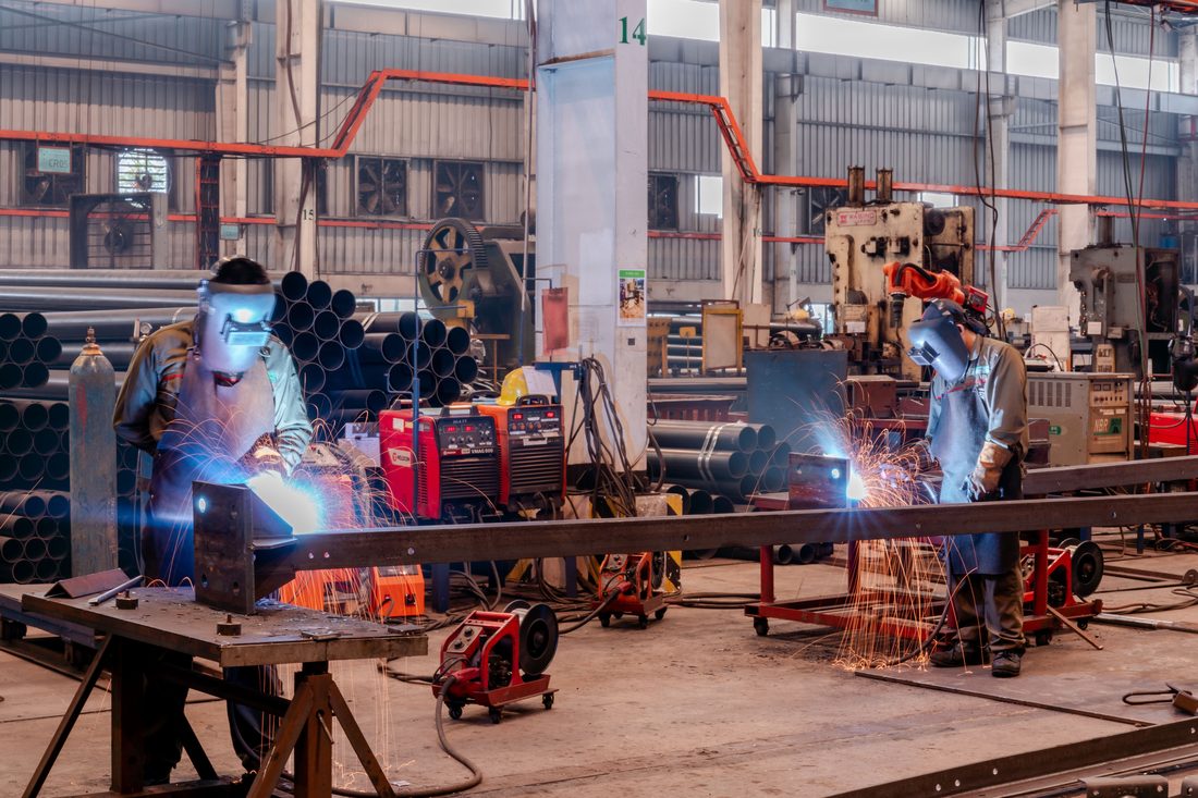 Deux soudeurs en équipement de protection dans un atelier industriel